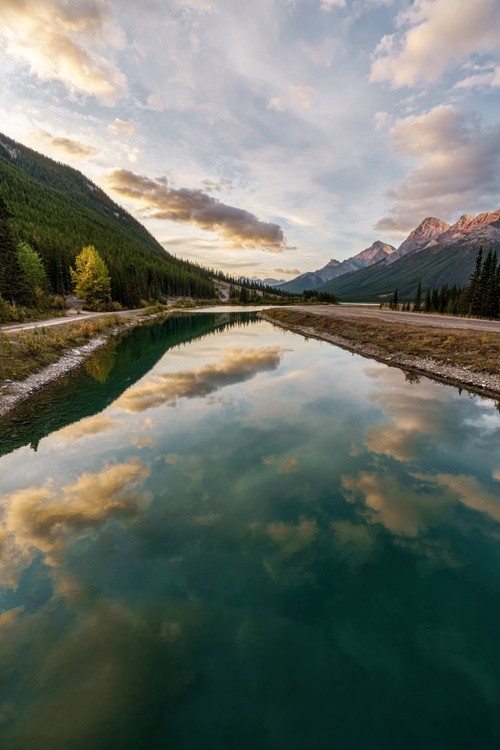 The cloud reflections enhance the river's green tinted color