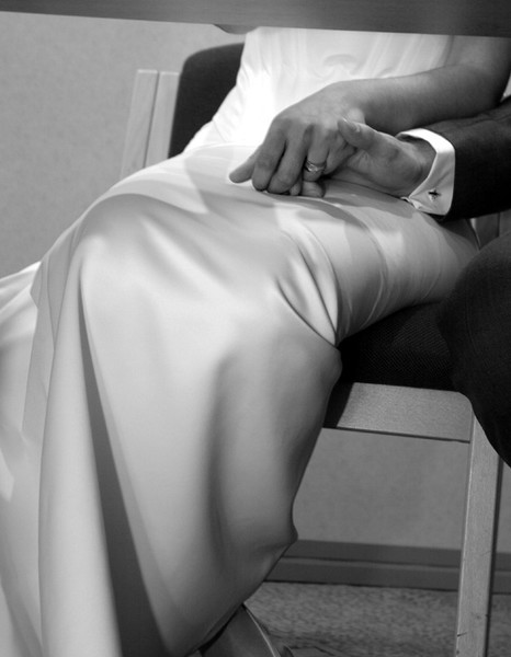 Bride and Groom holding hands under table
