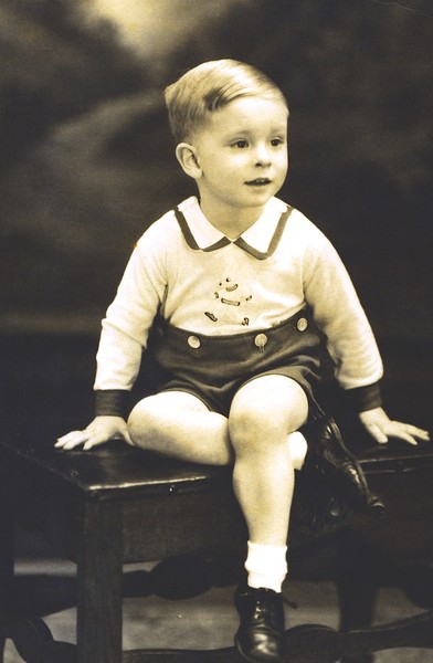 Young Boy Sitting on Piano Bench