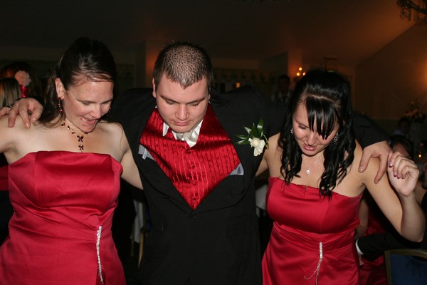 2 bridesmaids and the groom dancing