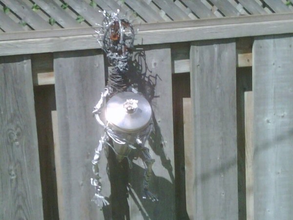Wire Man holding outdoor oil lamp