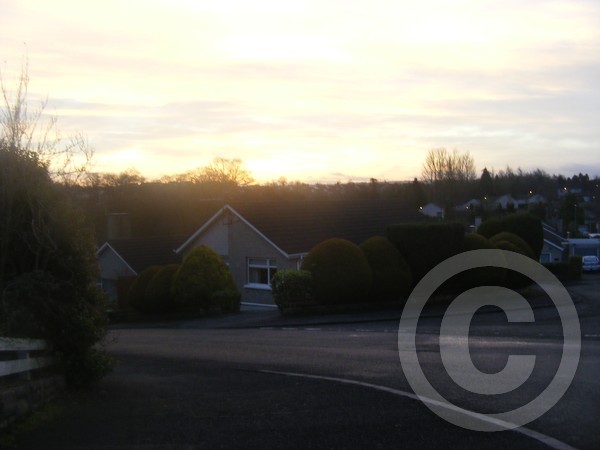 Sun rising behind house