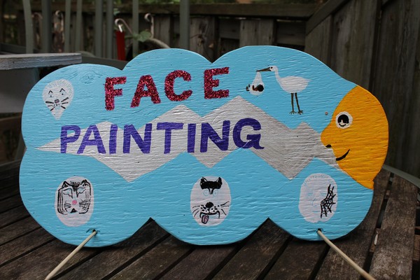 the front of a sign for a local face painter