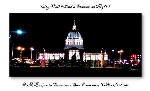 City Hall at night behind a Statute