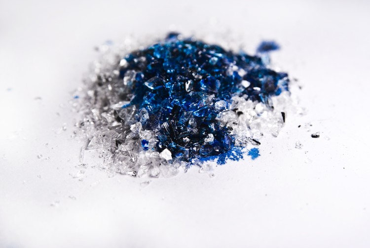 Pulverized glass with blue dye drips together.