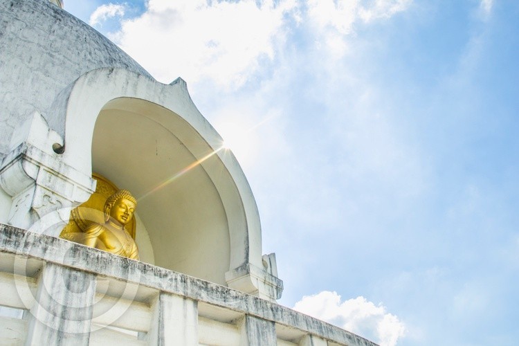 Low angle side view of Buddhist stupa covered by blue sky