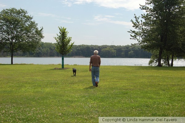 Man Walking His Dog Toward Lake