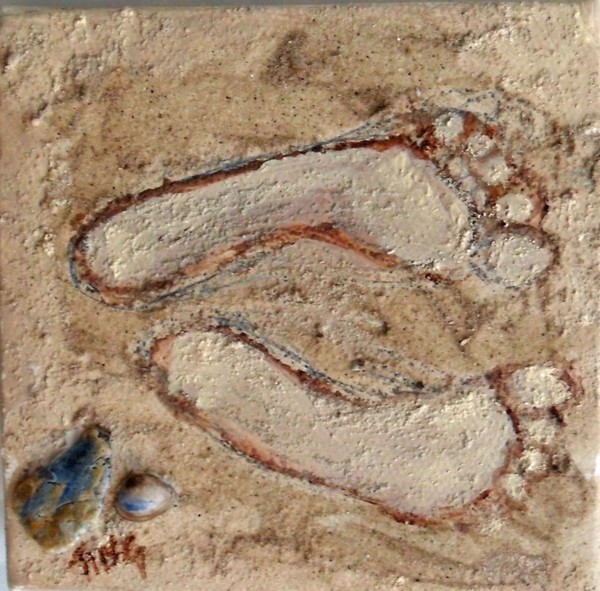 Foot Prints and Sea Shells left on a sandy beach