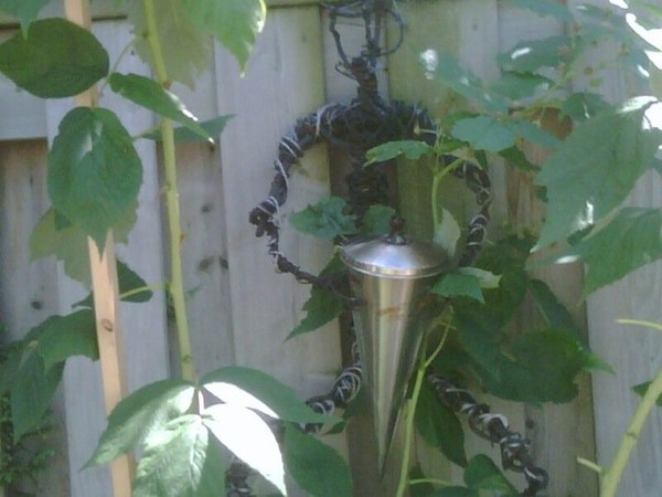 Large wire man holding outdoor oil lamp