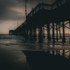 Sunsetting under the pier going bw